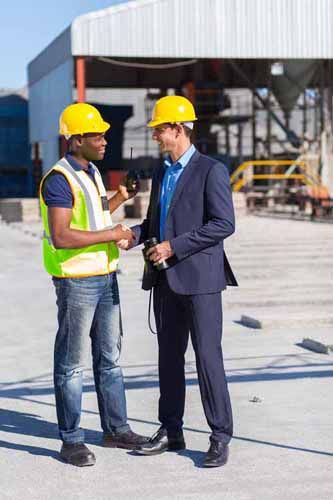 A man with a clipboard inspects a construction site